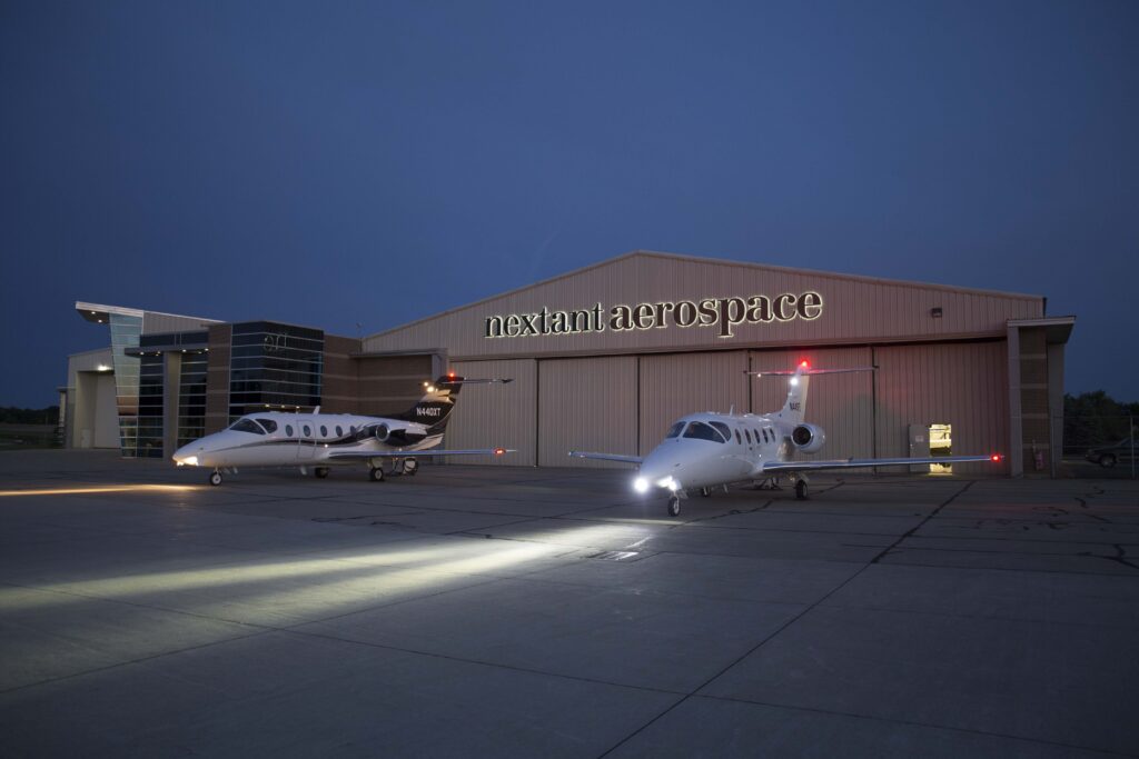 Twilight as two aircrafts shine their lights outside the Nextant Aerospace hanger